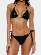 Woman wearing a black sequined bikini against a white background