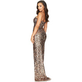 three quarter view of a woman wearing a gold sequined floor length gown with a high leg slit