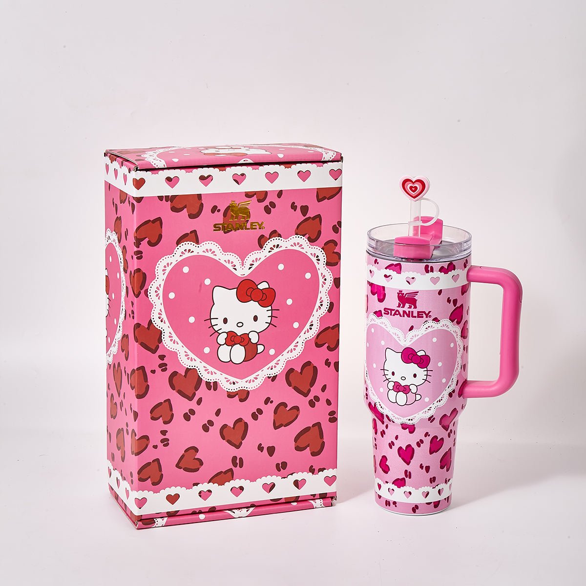 Pink Stanley tumbler with Hello Kitty graphic and heart pattern next to its box