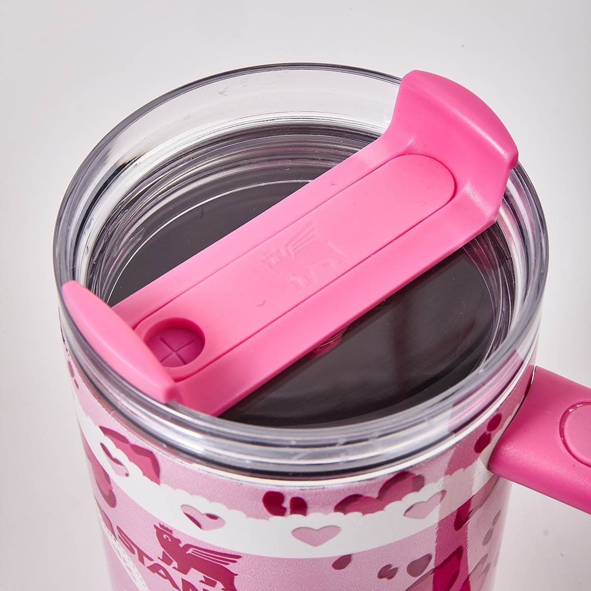 Close-up of the lid of the pink Stanley tumbler with Hello Kitty graphic and heart pattern