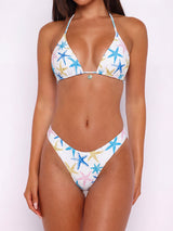 Woman wearing a white bikini with a starfish print, front view