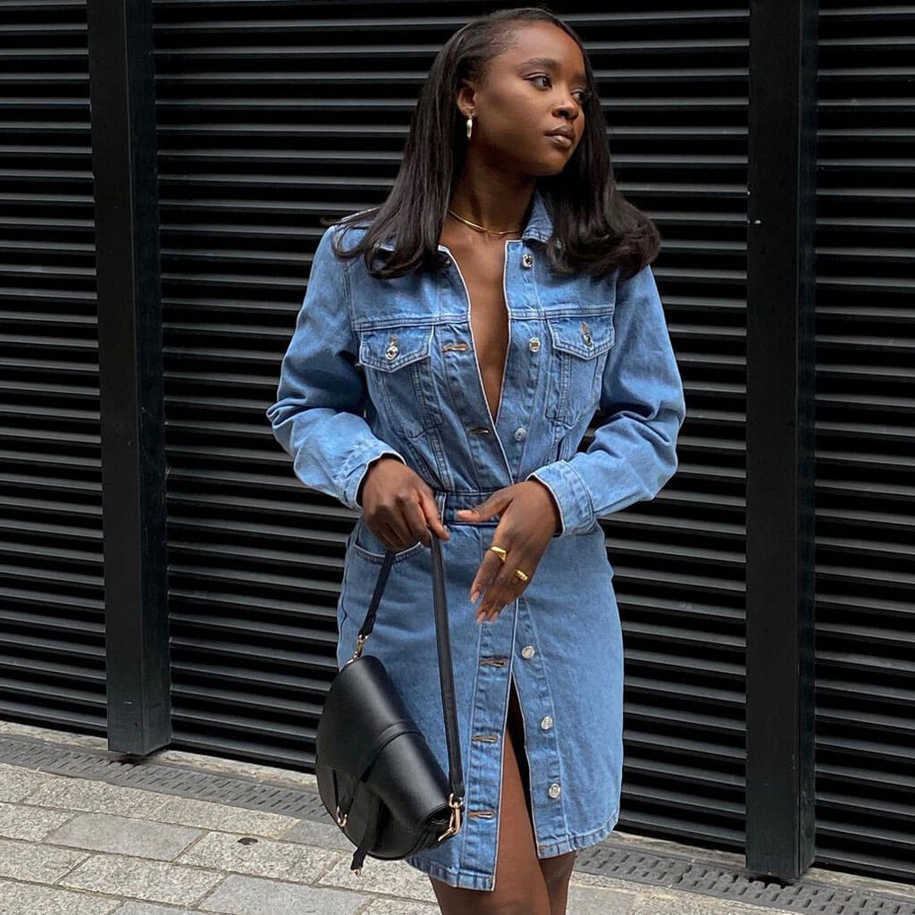 Woman wearing a blue denim shirt dress with a collared neckline and button-down front.
