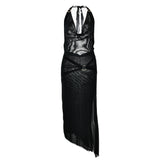 A black halter neck maxi dress with a sheer mesh overlay, velvet trim, metal rings, and a high slit, displayed flat.