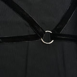 Detail of the velvet straps and metal ring accent on the bodice of a black sheer mesh dress.