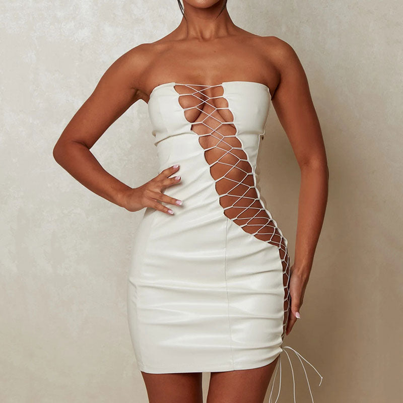 Woman wearing a white strapless faux leather mini dress with lace-up detailing on the front and sides