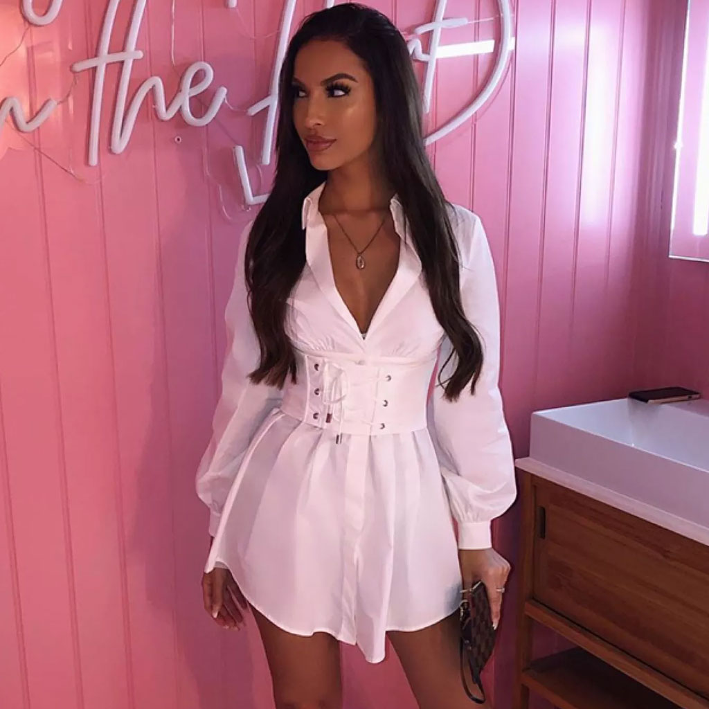 woman wearing a white button-down shirt dress with a corset belt