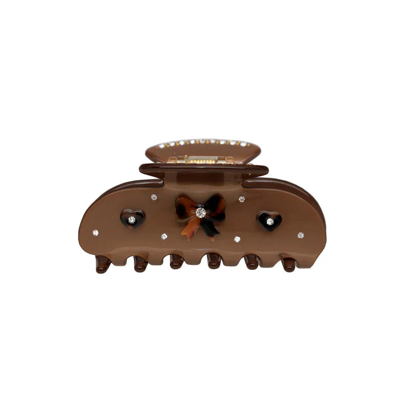 Brown claw clip with a tortoiseshell bow and heart embellishments