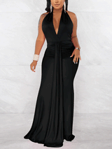 Woman wearing a long black halter dress with a deep V-neckline and ruched waist