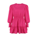 Product shot of a bright pink long-sleeved mini dress with a round neckline, elasticated waist, and tiered skirt.