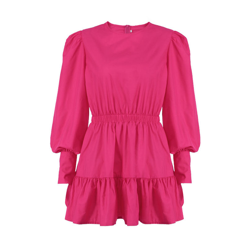 Product shot of a bright pink long-sleeved mini dress with a round neckline, elasticated waist, and tiered skirt.