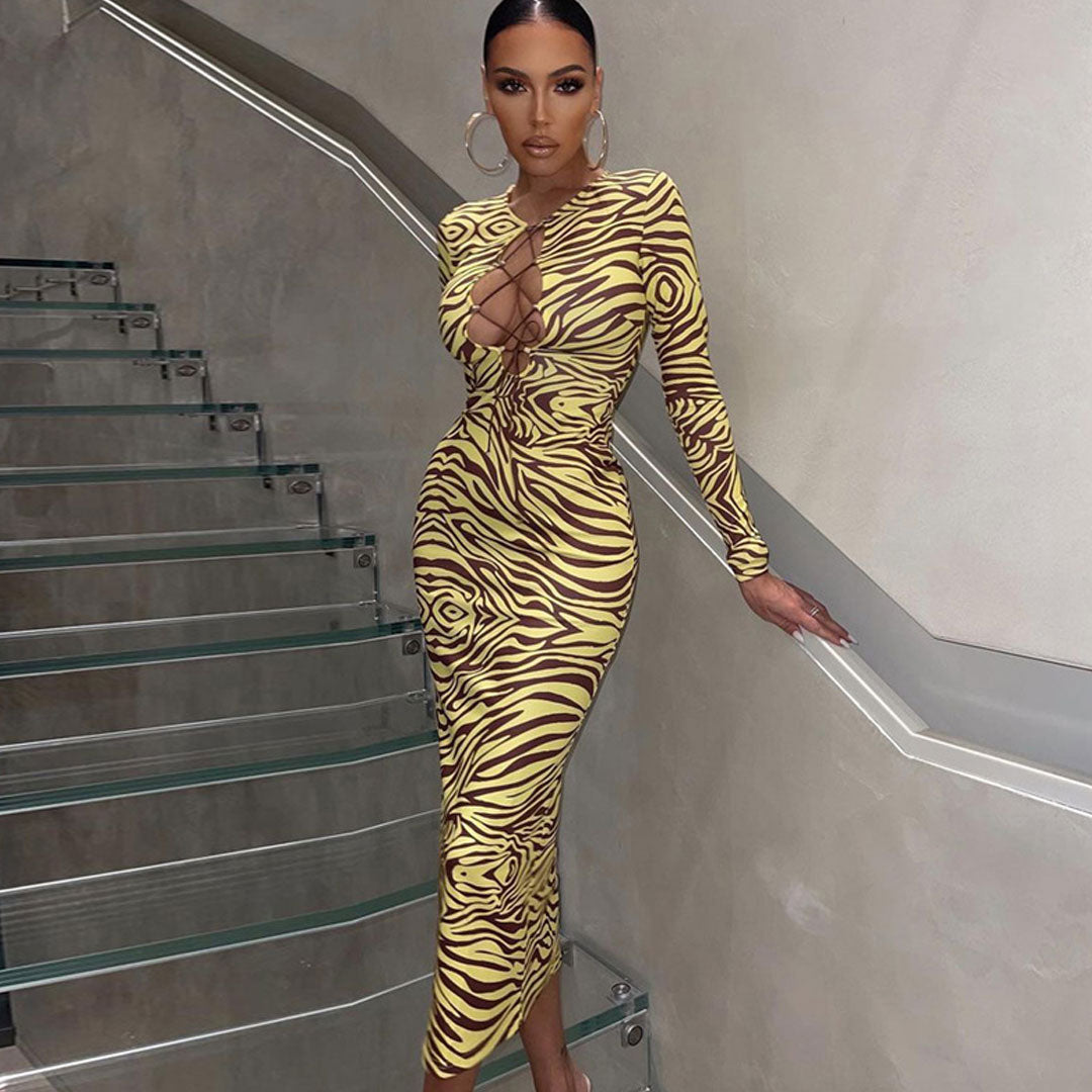 Full-length view of a woman in a zebra print midi dress with a lace-up neckline.