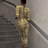 Rear view of a woman in a fitted zebra print midi dress with long sleeves.