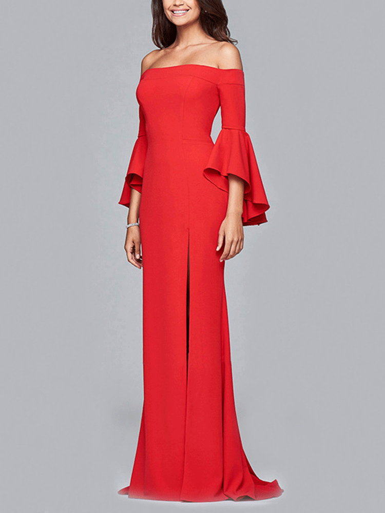 Side view of a woman in a red off-the-shoulder mermaid gown with bell sleeves and a high slit, against a gray background.