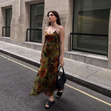 Woman walking down a street wearing a floral print midi slip dress.
