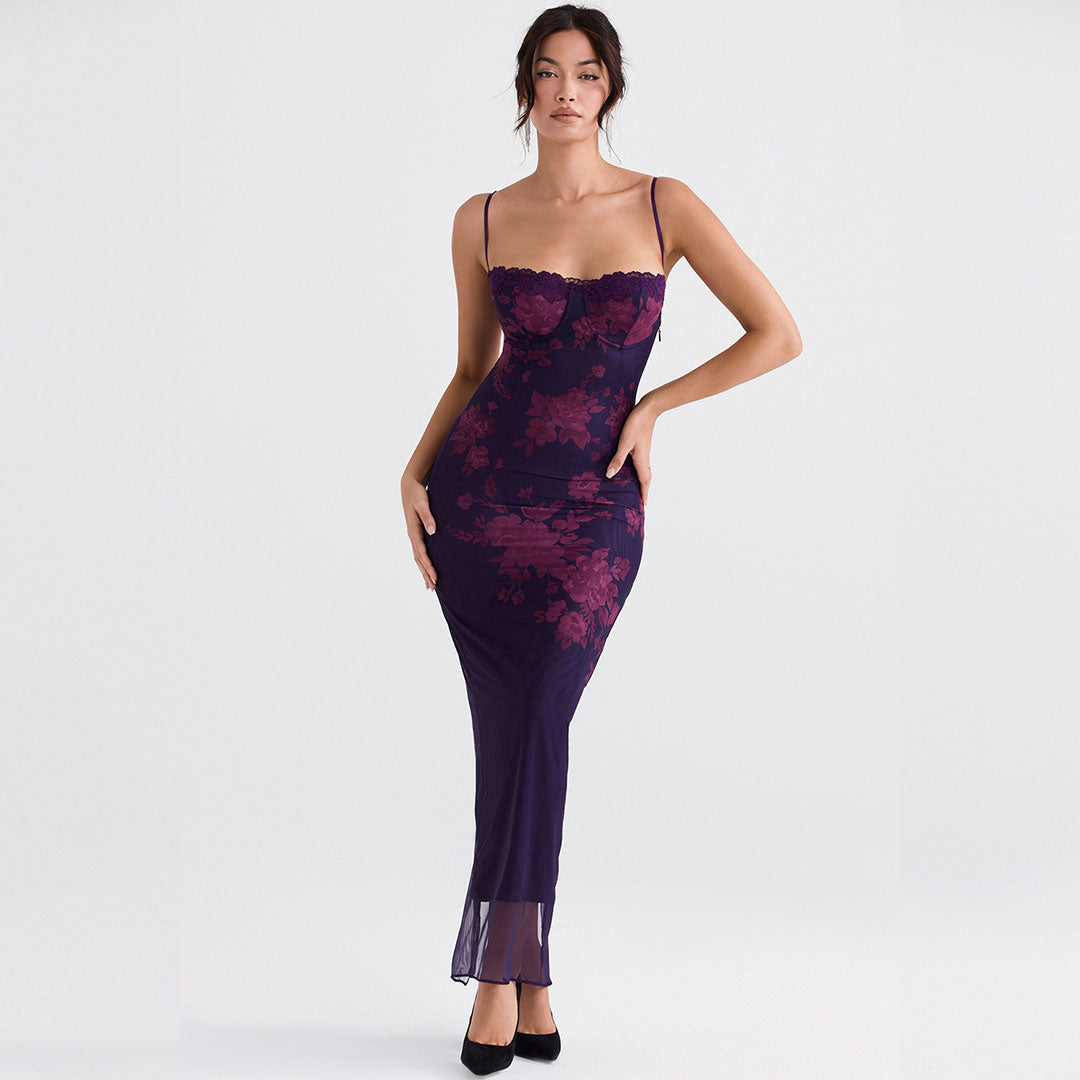 Woman wearing a long, dark purple mesh dress with a burgundy floral print and lace trim.