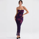 Woman wearing a long, dark purple mesh dress with a burgundy floral print and lace trim.