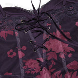 Close-up of the bodice of a dark purple dress, showing lace trim and center front lacing.