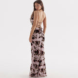 Back view of a woman in a floral print maxi dress with a lace-up detail.