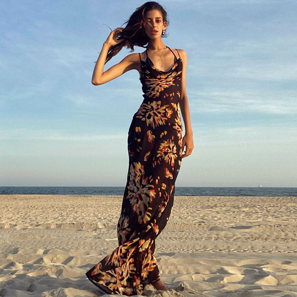 woman wearing a black floral print maxi dress standing on a beach
