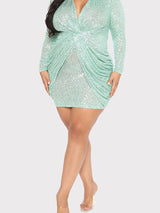 full body shot of a woman in a mint green sequined dress with long sleeves and a draped bodice