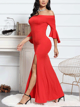 Side view of a woman in a red off-the-shoulder mermaid gown with bell sleeves and a high slit, showcasing the dress's fit.