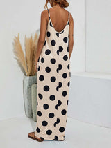 Woman wearing a beige polka dot maxi dress with spaghetti straps and pockets, back view